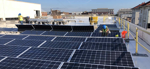 Daytime view of workers installing solar panels on the roof of the GSA R4 Gordon Building